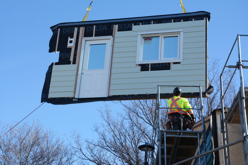 Side of modular home being craned into position